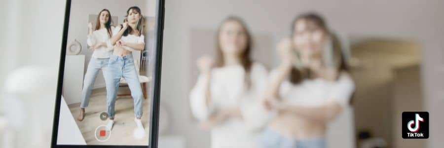Das Bild zeigt zwei junge Frauen, die ein TikTok Tanz-Video aufnehmen.